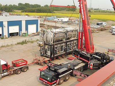 A large pump being lifted in the air by a crane