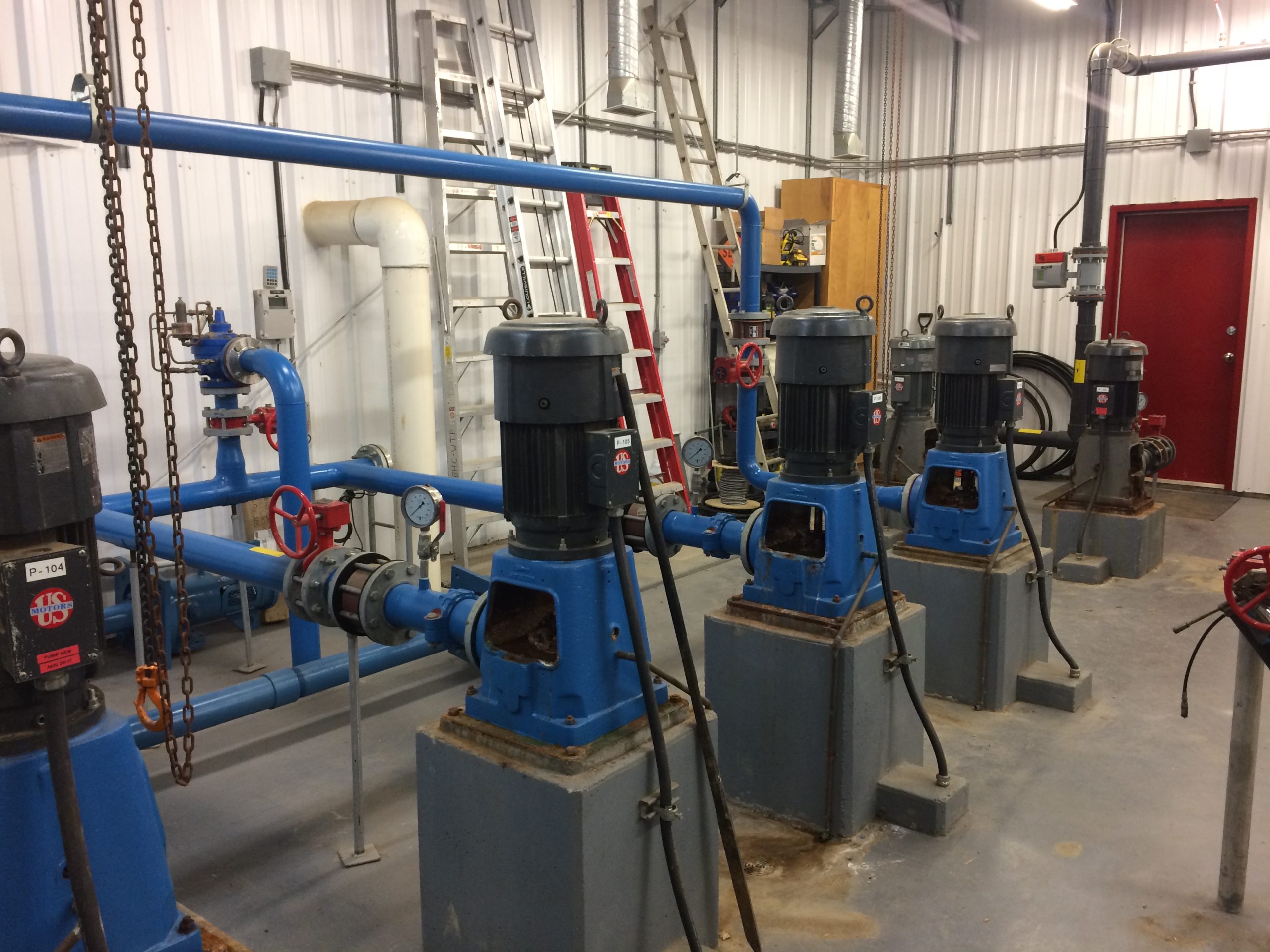 A group of industrial pumps in an industrial building.