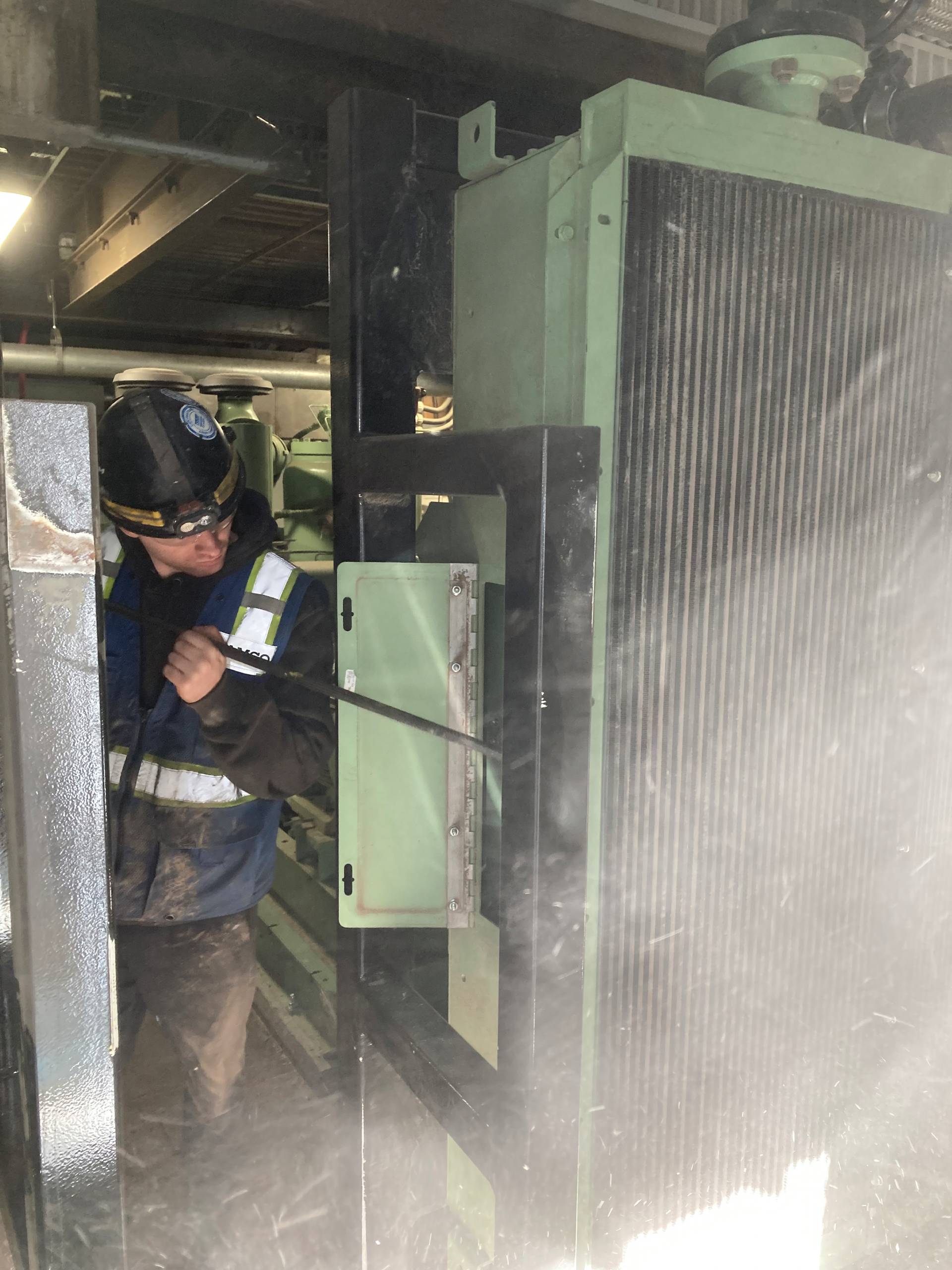 A service technician cleaning an aftercooler