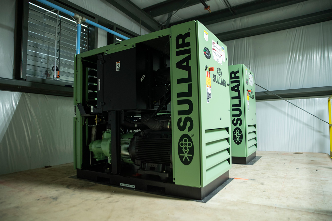 Sullair oil-flooded rotary screw air compressors in an industrial facility, part of a system undergoing regular compressor fluid analysis to ensure optimal performance and equipment longevity.