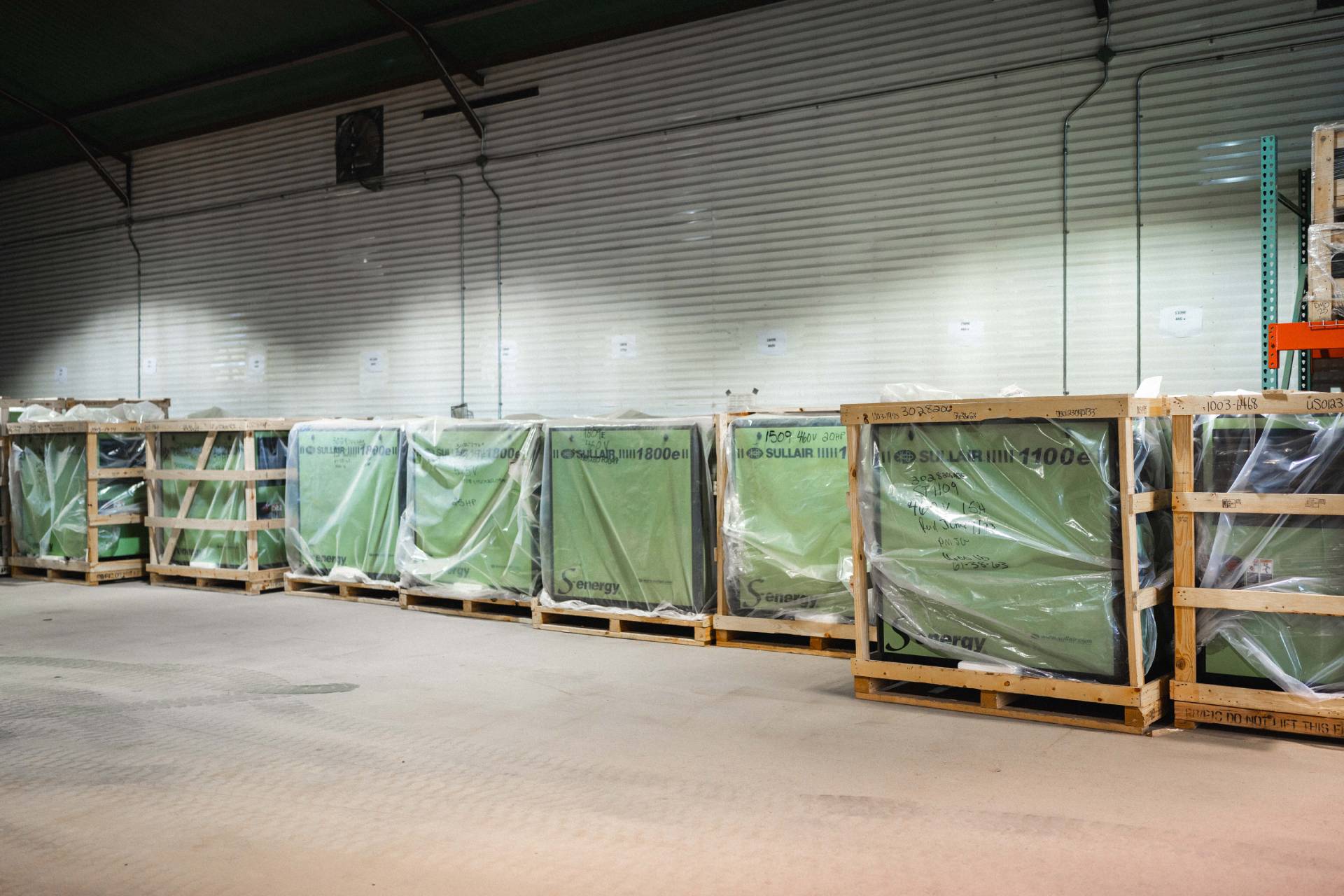 Crated Sullair industrial air compressors in storage, ready for shipment, highlighting options to consider when selecting the right compressor for your application.