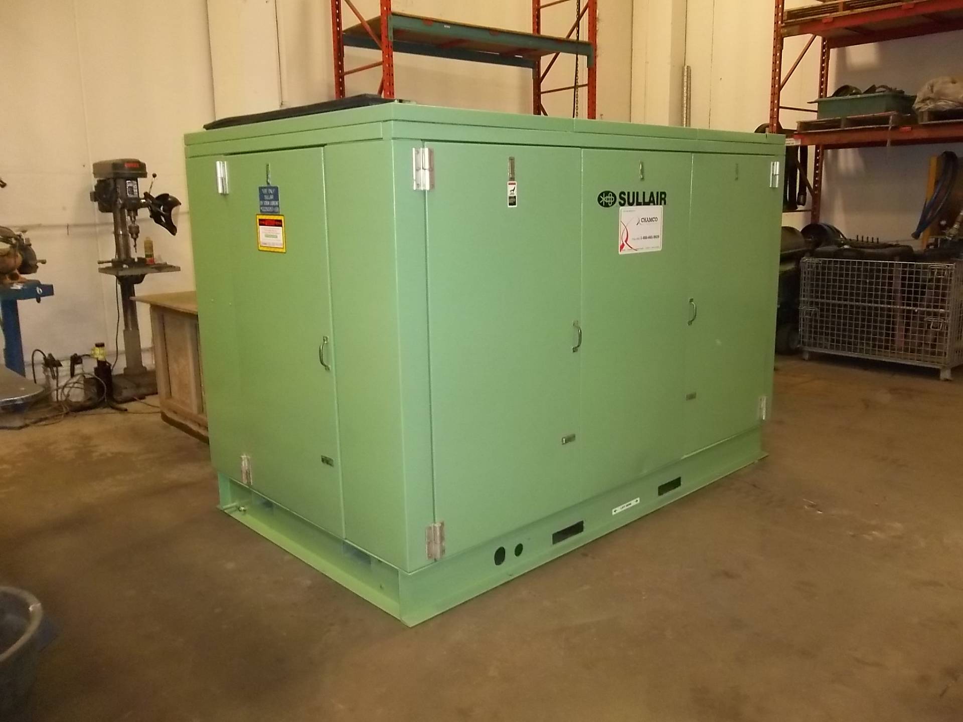 An industrial green air compressor displayed in a warehouse, illustrating the importance of volumetric efficiency in maximizing air delivery performance.