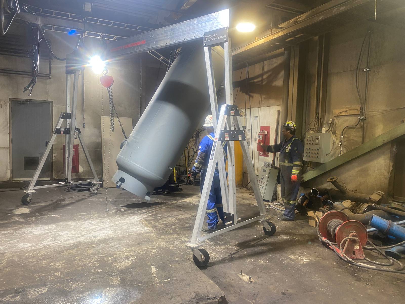 Compressed-Air-System-Progress Technicians positioning compressed air equipment using a gantry crane during Phase One of a new air system installation featuring a Sullair TS32-350H compressor.