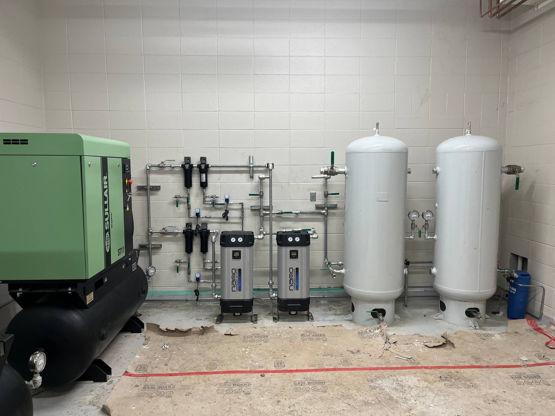 Complete compressed air system with compressors, dryers, and piping, custom-installed and fabricated to meet building specifications at a technical training facility.