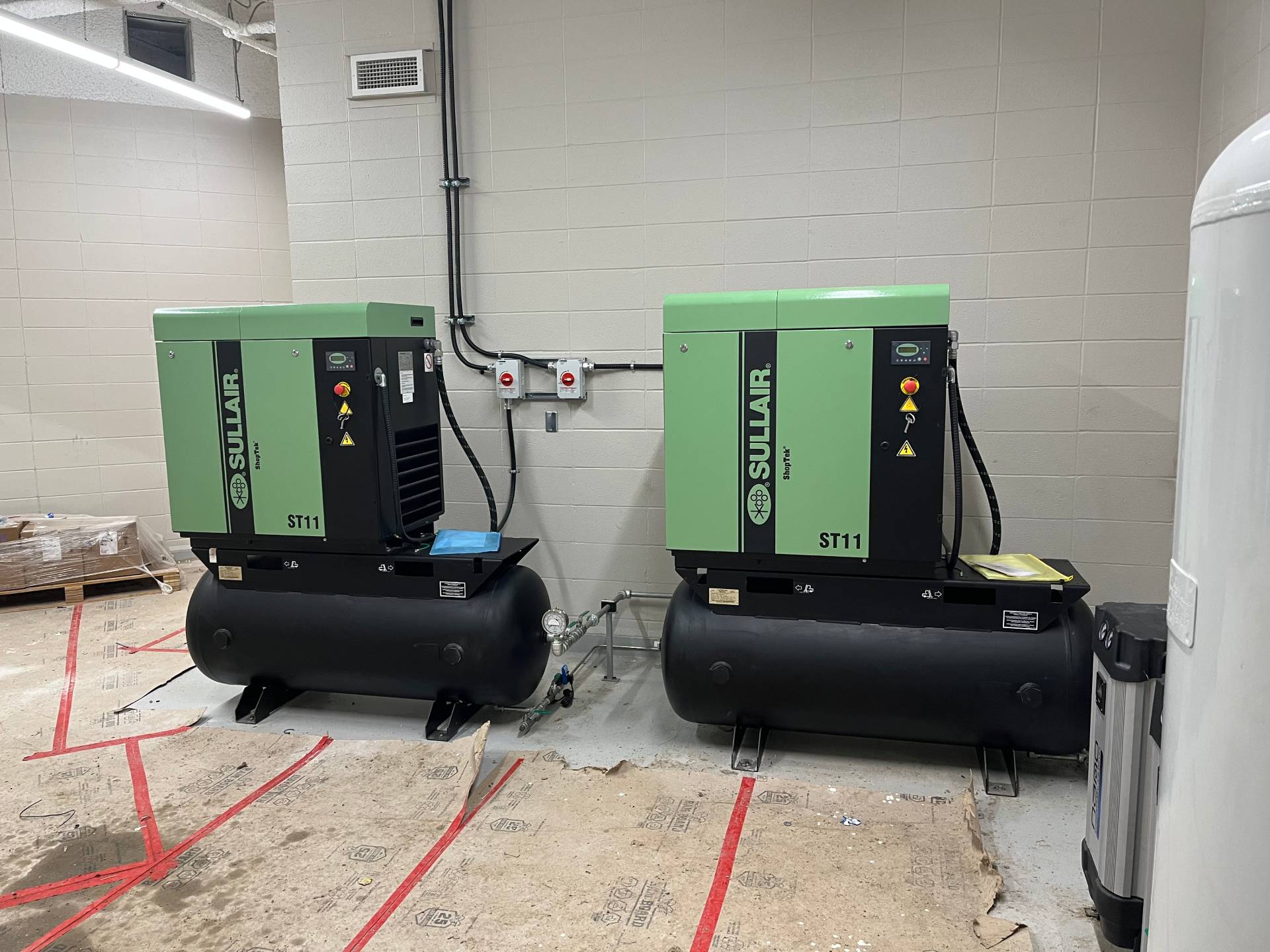 Two ST1112R Sullair compressors installed in a technical training facility, positioned for accessibility and educational demonstration.
