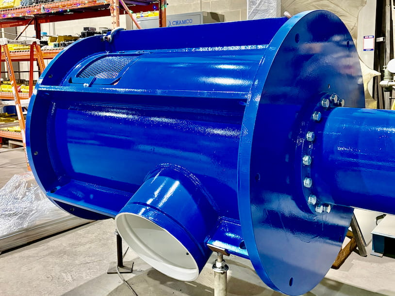 Vertical turbine pump discharge head with discharge flange and motor mount, painted blue, staged in Chamco's fabrication shop
